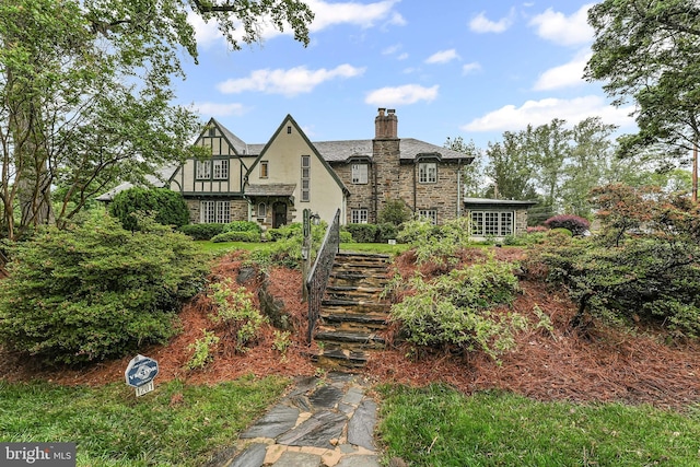 1201 Grenox Rd, Wynnewood, PA 19096 - view of front of house with stone siding, a chimney, and stairway