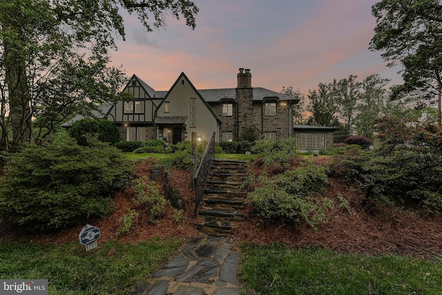 1201 Grenox Rd, Wynnewood, PA 19096 - tudor-style house with stairway, a chimney, stone siding, and stucco siding