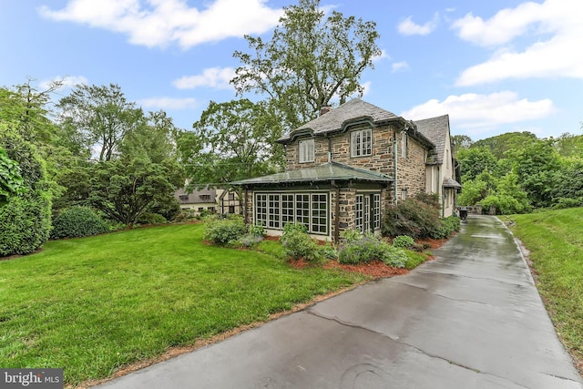 1201 Grenox Rd, Wynnewood, PA 19096 - rear view of house with stone siding, concrete driveway, a yard, and a chimney
