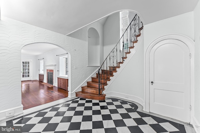 1201 Grenox Rd, Wynnewood, PA 19096 - stairway with healthy amount of natural light, a brick fireplace, arched walkways, and baseboards