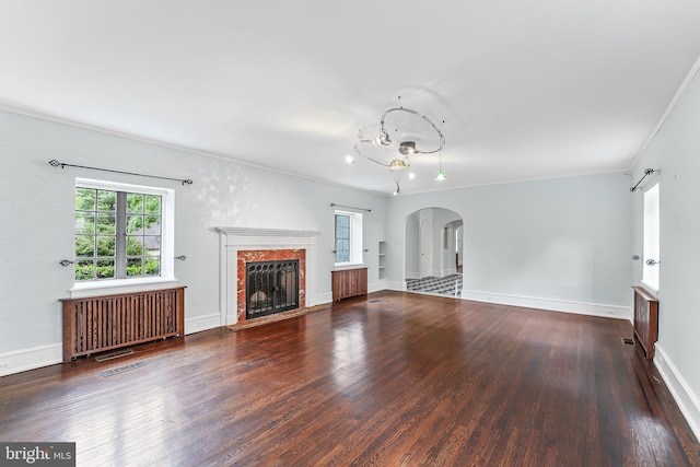 1201 Grenox Rd, Wynnewood, PA 19096 - unfurnished living room featuring radiator heating unit, wood finished floors, arched walkways, a fireplace, and ornamental molding