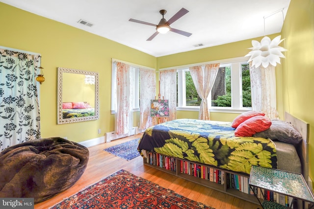 15 Jefferson Ave, Takoma Park, MD 20912 - bedroom with wood finished floors, baseboards, a baseboard heating unit, a ceiling fan, and attic access