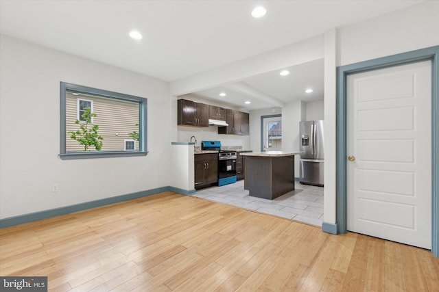 603 Vernon St, Media, PA 19063 - kitchen with stainless steel appliances, dark brown cabinetry, light wood-type flooring, under cabinet range hood, and baseboards
