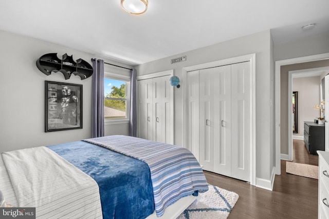2302 Solmar Dr, Silver Spring, MD 20904 - bedroom featuring two closets, dark wood finished floors, and baseboards