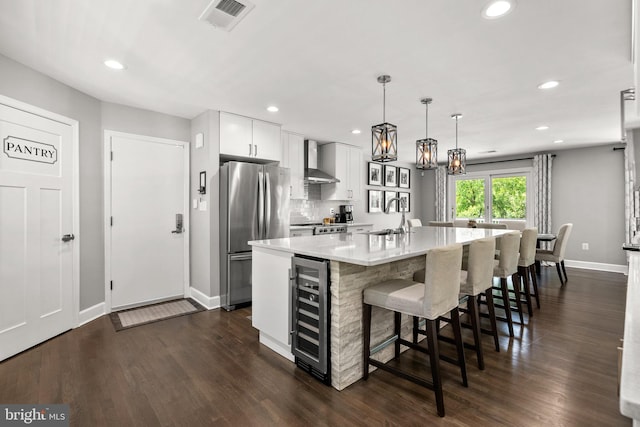 2302 Solmar Dr, Silver Spring, MD 20904 - kitchen with freestanding refrigerator, beverage cooler, wall chimney exhaust hood, baseboards, and light countertops