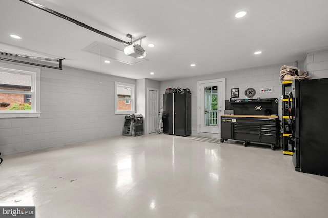 2302 Solmar Dr, Silver Spring, MD 20904 - garage featuring a garage door opener, concrete block wall, freestanding refrigerator, and recessed lighting