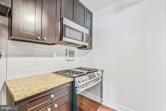 3601 5th St S Unit 211, Arlington, VA 22204 - kitchen with appliances with stainless steel finishes, baseboards, light wood-style floors, decorative backsplash, and dark brown cabinets