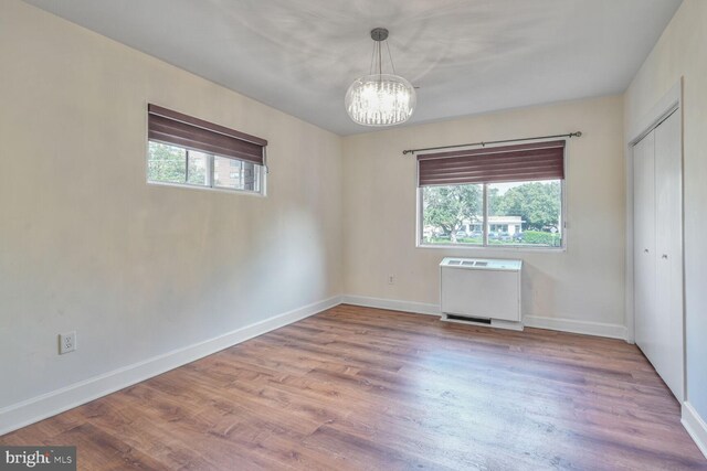 3601 5th St S Unit 211, Arlington, VA 22204 - unfurnished bedroom featuring a chandelier, wood finished floors, baseboards, and a closet