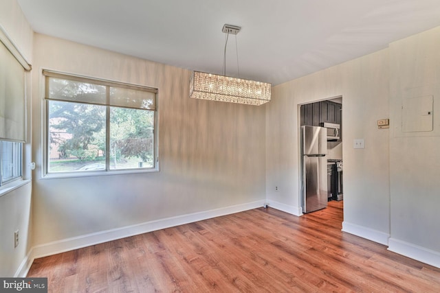 3601 5th St S Unit 211, Arlington, VA 22204 - unfurnished room with a chandelier, wood finished floors, and baseboards