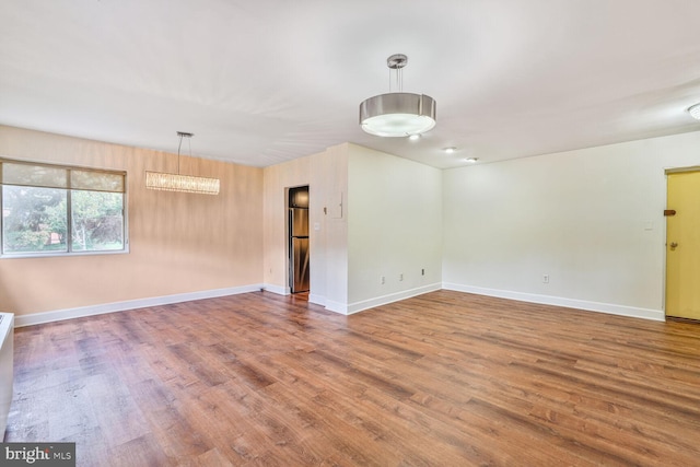3601 5th St S Unit 211, Arlington, VA 22204 - empty room with wood finished floors, baseboards, and a chandelier