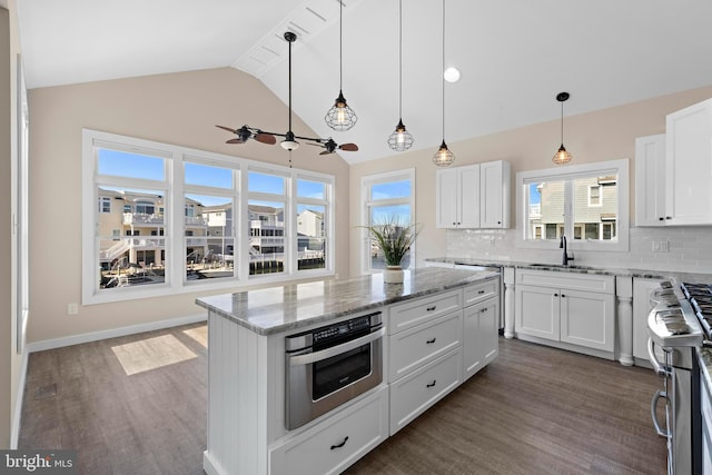 1169 Jennifer Ln, Manahawkin, NJ 08050 - kitchen featuring stainless steel appliances, a sink, dark wood-style floors, tasteful backsplash, and white cabinetry
