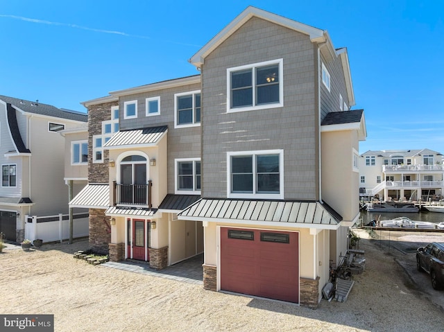 1169 Jennifer Ln, Manahawkin, NJ 08050 - townhome / multi-family property featuring a standing seam roof, stone siding, an attached garage, driveway, and metal roof