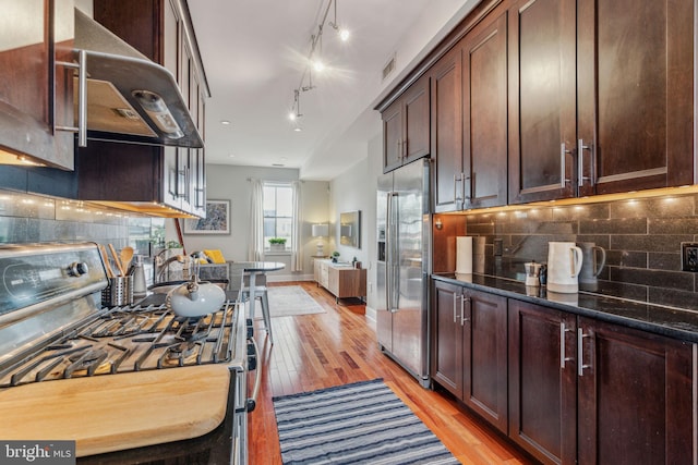 2031 Pine St Unit 4, Philadelphia, PA 19103 - kitchen with gas range oven, stainless steel fridge with ice dispenser, extractor fan, light wood-type flooring, and backsplash