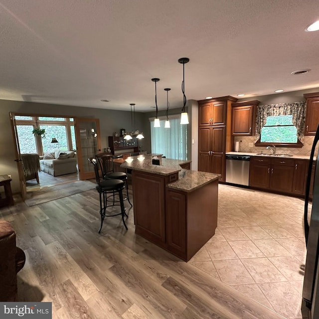 8201 Michaux Dr, Fayetteville, PA 17222 - kitchen with stainless steel dishwasher, a kitchen island, a sink, backsplash, and plenty of natural light