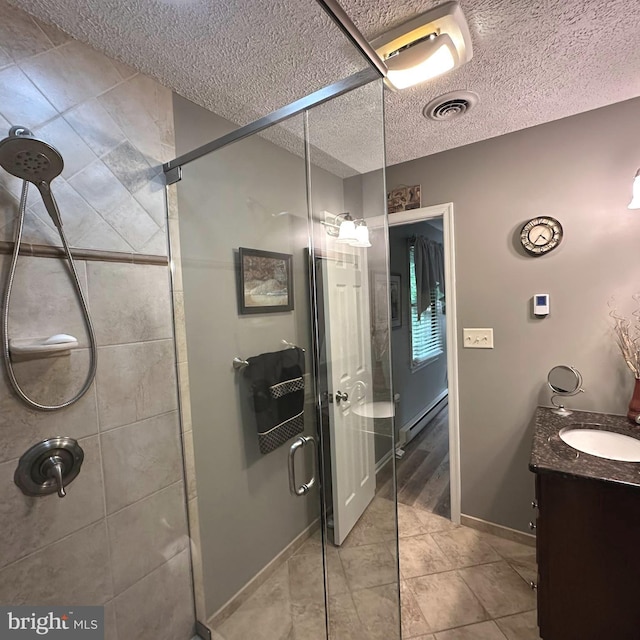 8201 Michaux Dr, Fayetteville, PA 17222 - full bathroom featuring a stall shower, a baseboard heating unit, vanity, a textured ceiling, and tile patterned flooring