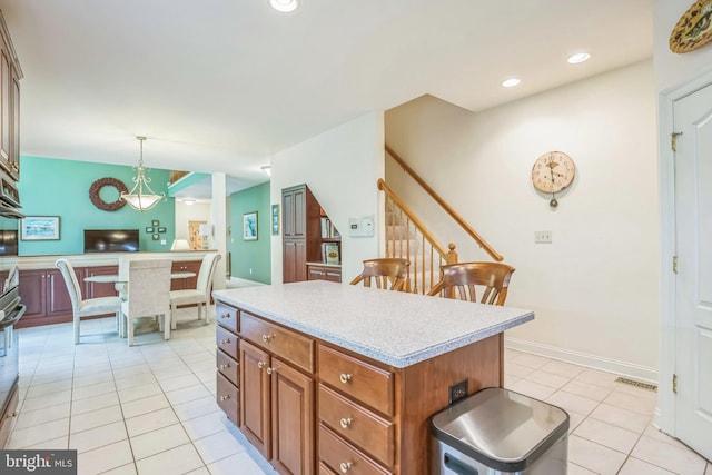 40801 Kiskadee Ln, Leonardtown, MD 20650 - kitchen featuring light tile patterned floors, light countertops, a kitchen island, brown cabinets, and pendant lighting