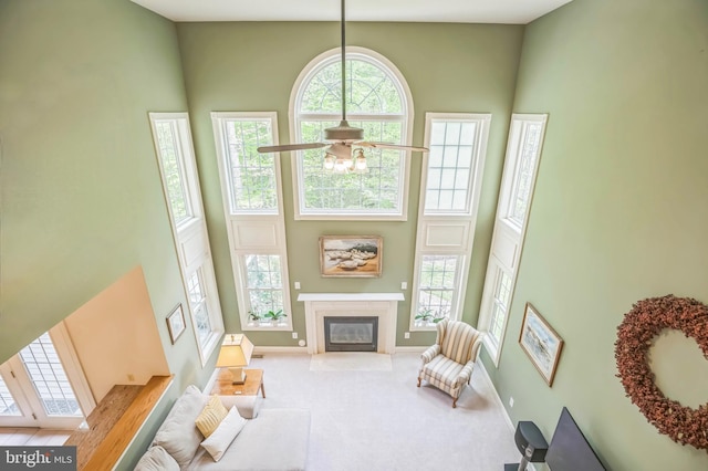 40801 Kiskadee Ln, Leonardtown, MD 20650 - carpeted living room with a high ceiling, a fireplace with flush hearth, a ceiling fan, and baseboards