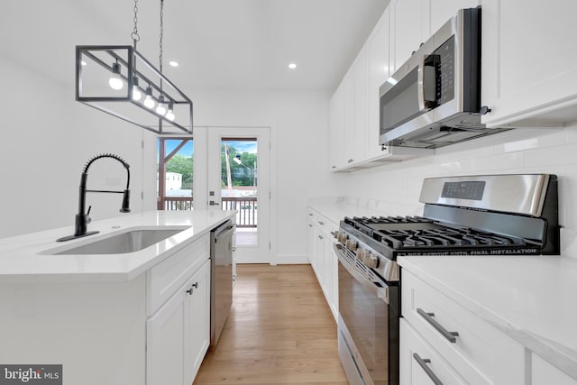 5318 5th St NW, Washington, DC 20011 - kitchen with appliances with stainless steel finishes, a sink, light wood-type flooring, light countertops, and tasteful backsplash