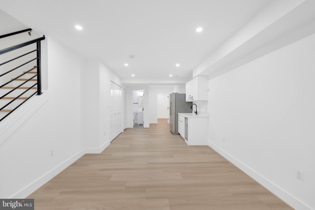 5318 5th St NW, Washington, DC 20011 - hallway with baseboards, light wood-style floors, recessed lighting, a sink, and stairs