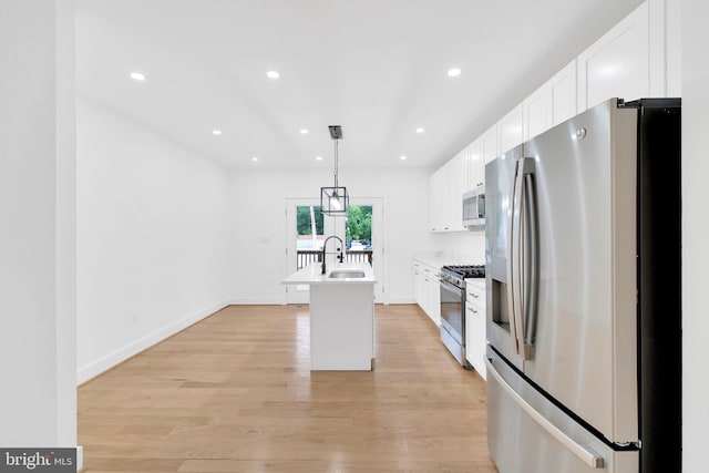 5318 5th St NW, Washington, DC 20011 - kitchen featuring stainless steel appliances, a sink, white cabinetry, a kitchen island with sink, and light wood-type flooring