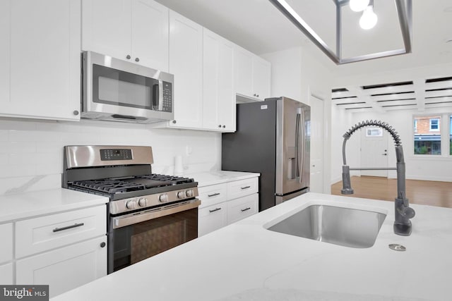 5318 5th St NW, Washington, DC 20011 - kitchen featuring appliances with stainless steel finishes, a sink, white cabinets, decorative backsplash, and coffered ceiling