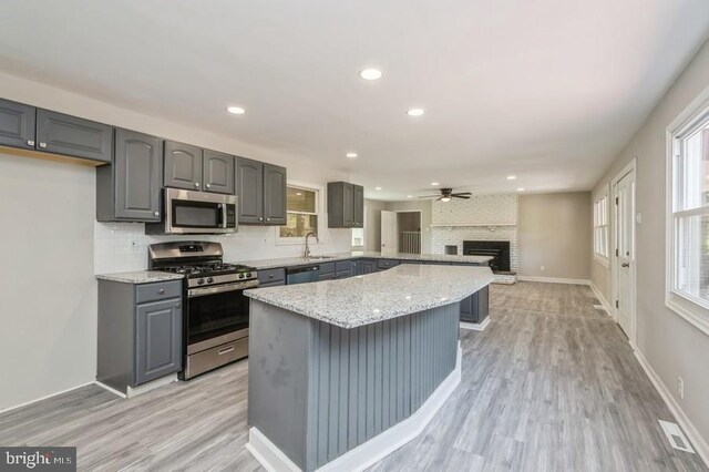 2336 Auburn Ave, Atco, NJ 08004 - kitchen with appliances with stainless steel finishes, gray cabinets, a fireplace, light wood-type flooring, and ceiling fan