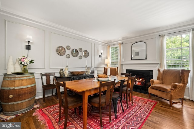 43614 Dunhill Cup Sq, Ashburn, VA 20147 - dining area featuring a decorative wall, ornamental molding, a fireplace with flush hearth, and wood finished floors