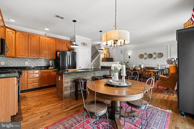 43614 Dunhill Cup Sq, Ashburn, VA 20147 - dining space featuring wood finished floors, a chandelier, and ornamental molding
