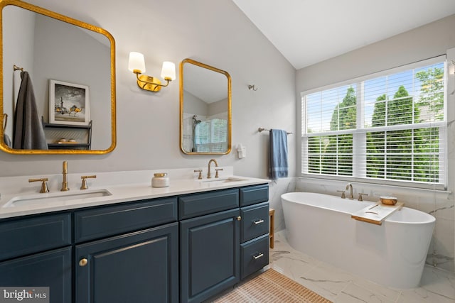 43614 Dunhill Cup Sq, Ashburn, VA 20147 - bathroom with marble finish flooring, lofted ceiling, double vanity, a freestanding bath, and tile walls