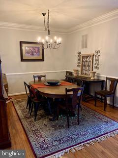 43614 Dunhill Cup Sq, Ashburn, VA 20147 - dining area featuring wood finished floors, a chandelier, ornamental molding, and baseboards
