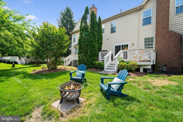43614 Dunhill Cup Sq, Ashburn, VA 20147 - rear view of property with an outdoor fire pit, a lawn, a wooden deck, stairway, and a chimney