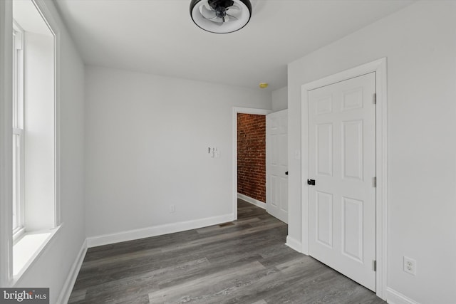233 S Frazier St, Philadelphia, PA 19139 - unfurnished room with brick wall, baseboards, and wood finished floors