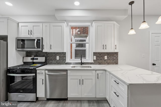 233 S Frazier St, Philadelphia, PA 19139 - kitchen featuring stainless steel appliances, a sink, a peninsula, white cabinets, and recessed lighting