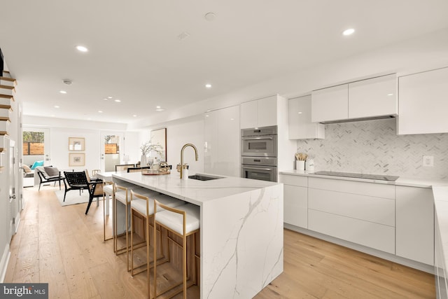 1202 Eton Ct NW Unit T3, Washington, DC 20007 - kitchen featuring a sink, modern cabinets, stainless steel double oven, white cabinets, and light wood-style floors