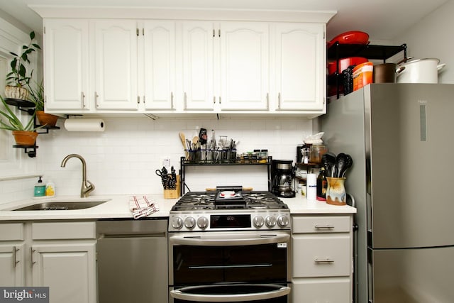 1702 Lang Pl NE, Washington, DC 20002 - kitchen featuring a sink, appliances with stainless steel finishes, white cabinets, and light countertops