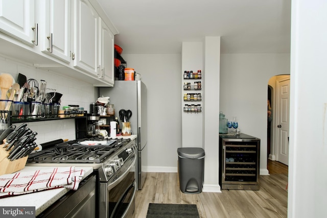 1702 Lang Pl NE, Washington, DC 20002 - kitchen with stainless steel range with gas cooktop, wine cooler, backsplash, light wood-type flooring, and white cabinets