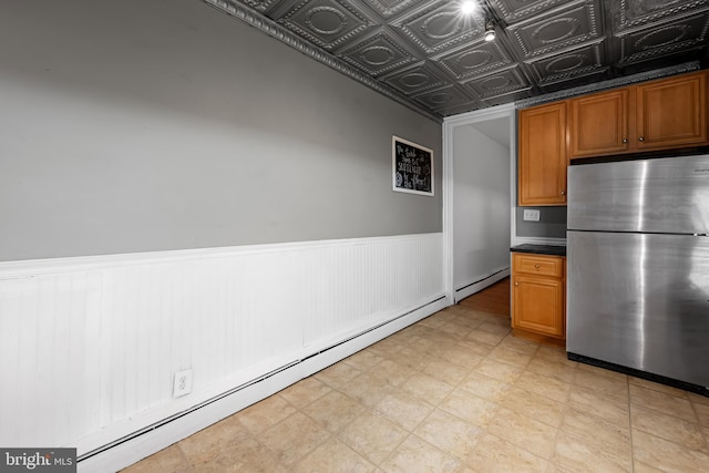 812 Powers St, Baltimore, MD 21211 - kitchen featuring freestanding refrigerator, a baseboard radiator, dark countertops, a wainscoted wall, and an ornate ceiling
