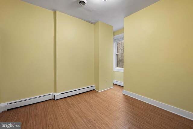 812 Powers St, Baltimore, MD 21211 - spare room with baseboard heating, wood finished floors, and baseboards