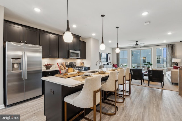 16519 Saint Marion Way, Bowie, MD 20716 - kitchen with appliances with stainless steel finishes, a sink, open floor plan, light wood finished floors, and light countertops