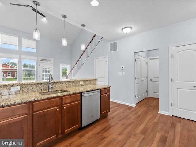 306 Prospect St, Milton, DE 19968 - kitchen with dishwasher, a sink, wood finished floors, hanging light fixtures, and light stone counters
