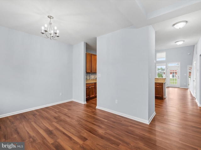 306 Prospect St, Milton, DE 19968 - spare room with a chandelier, dark wood finished floors, and baseboards