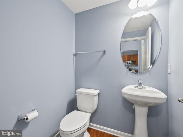 306 Prospect St, Milton, DE 19968 - half bathroom featuring toilet, wood finished floors, and baseboards