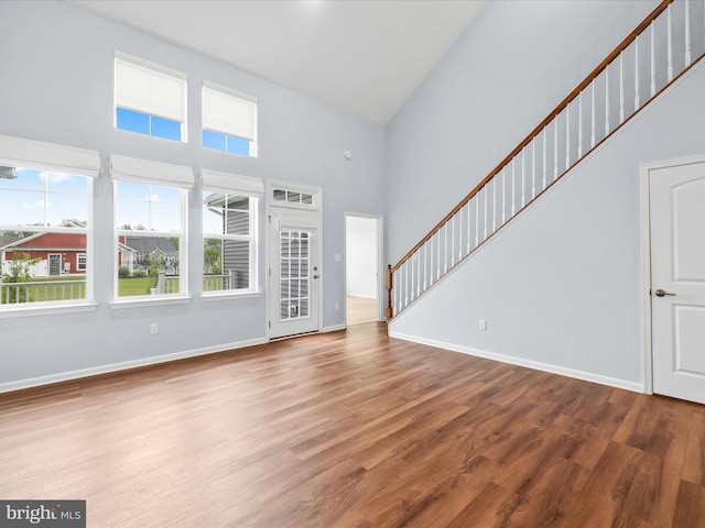 306 Prospect St, Milton, DE 19968 - unfurnished living room featuring a high ceiling, wood finished floors, baseboards, and stairway