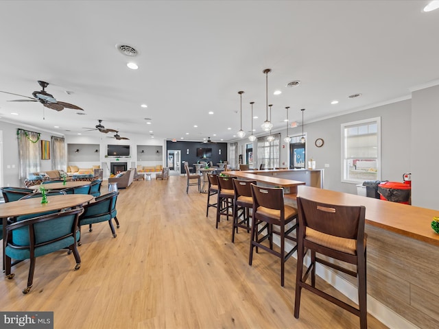 306 Prospect St, Milton, DE 19968 - dining space featuring ornamental molding, light wood-type flooring, recessed lighting, ceiling fan, and a warm lit fireplace