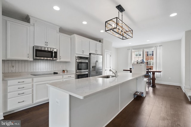 8486 Craggan Ln, Manassas, VA 20109 - kitchen with stainless steel appliances, a sink, a center island with sink, decorative backsplash, and recessed lighting