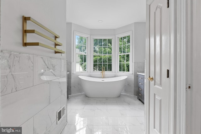 411 Merion Hill Ln, Conshohocken, PA 19428 - full bath featuring tile walls, marble look tile flooring, a soaking tub, and a wainscoted wall