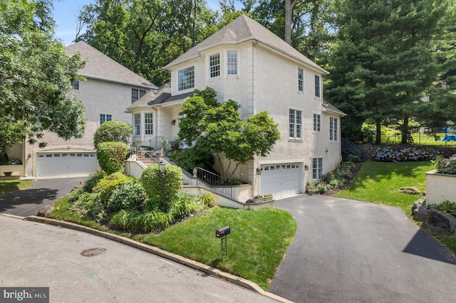 411 Merion Hill Ln, Conshohocken, PA 19428 - view of front facade featuring driveway, a garage, a front lawn, and stucco siding