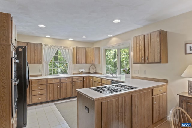 2 Whippoorwill Ln, Palmyra, VA 22963 - kitchen featuring stainless steel gas stovetop, a peninsula, brown cabinetry, a sink, and light countertops