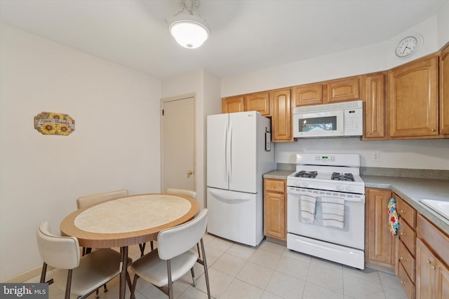 2904 Armstrong Ave, Secane, PA 19018 - kitchen with white appliances, light tile patterned floors, light countertops, and brown cabinets