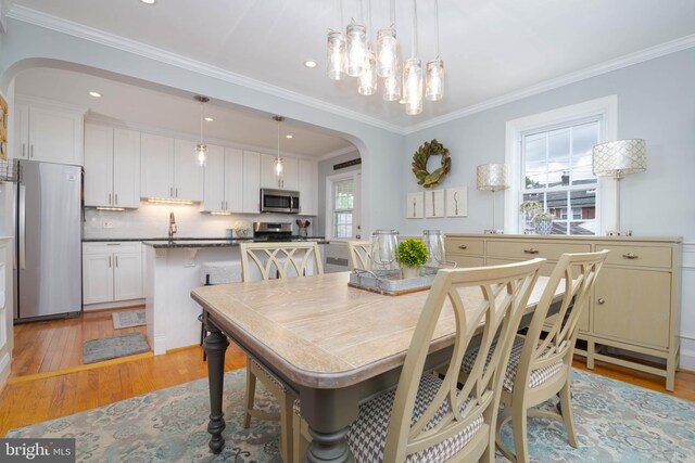 409 Regester Ave, Baltimore, MD 21212 - dining space featuring arched walkways, light wood-style floors, ornamental molding, and recessed lighting
